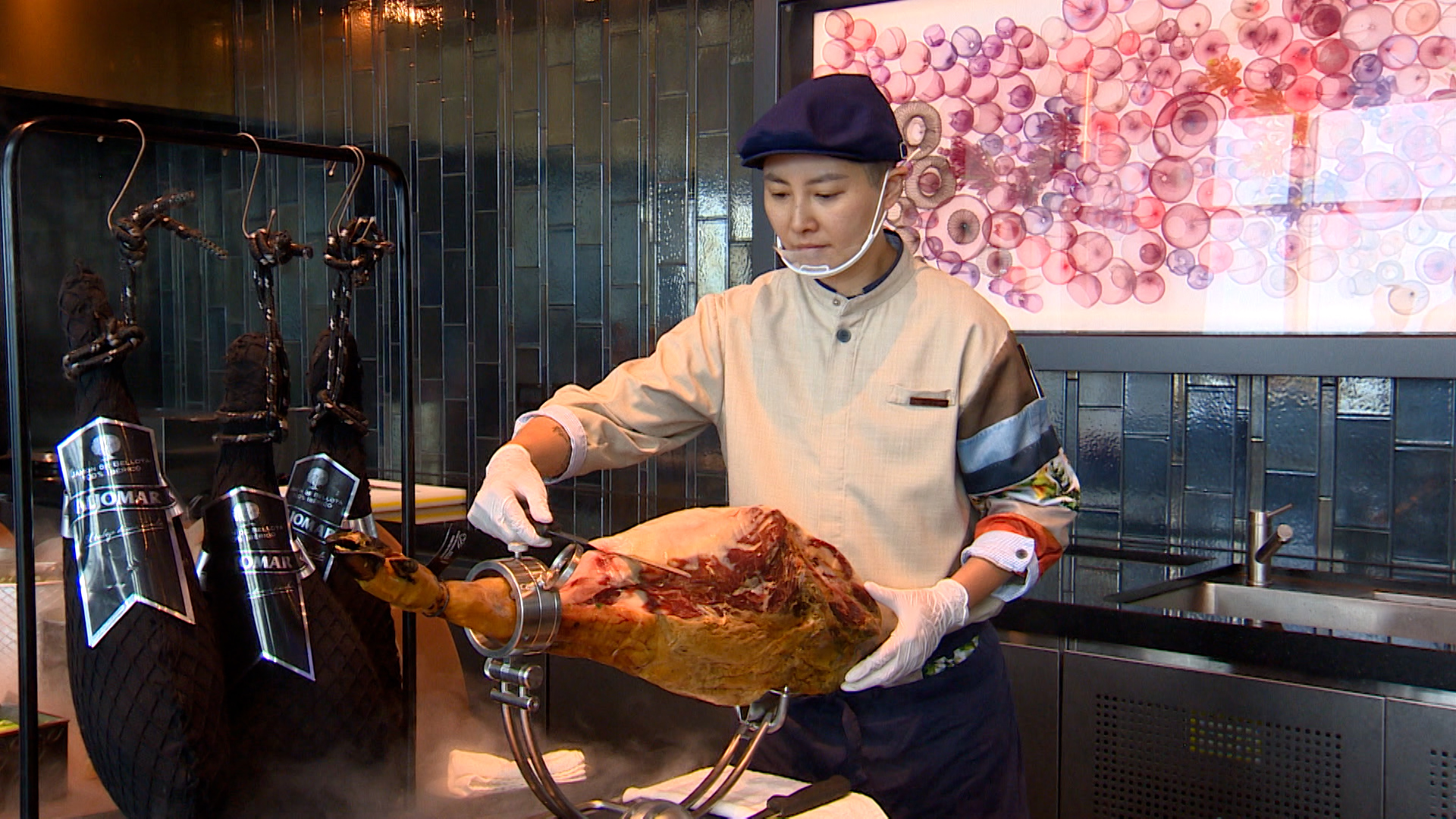 侍肉師精準俐落的切下一片片透光薄如紙的伊比利火腿。（圖／東森新聞）