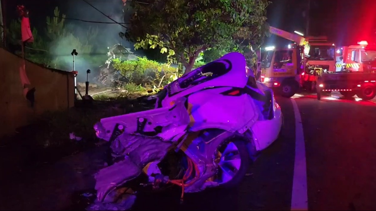 一輛特斯拉疑從國道1號南下車道墜橋，導致車輛撞成兩半。（圖／東森新聞）