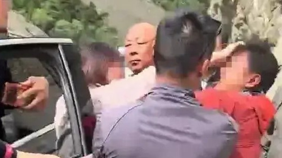 中國一名女孕婦在車陣中和其他男子發生爭執。（圖／翻攝自 Vista看天下 微博）