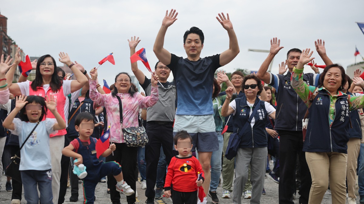 台北市政府113年國慶升旗暨慶祝活動10日上午在市民廣場盛大登場，市長蔣萬安（中）帶著兩個兒子參加國慶慢跑，出發前與民眾一同做暖身操。（圖／中央社）