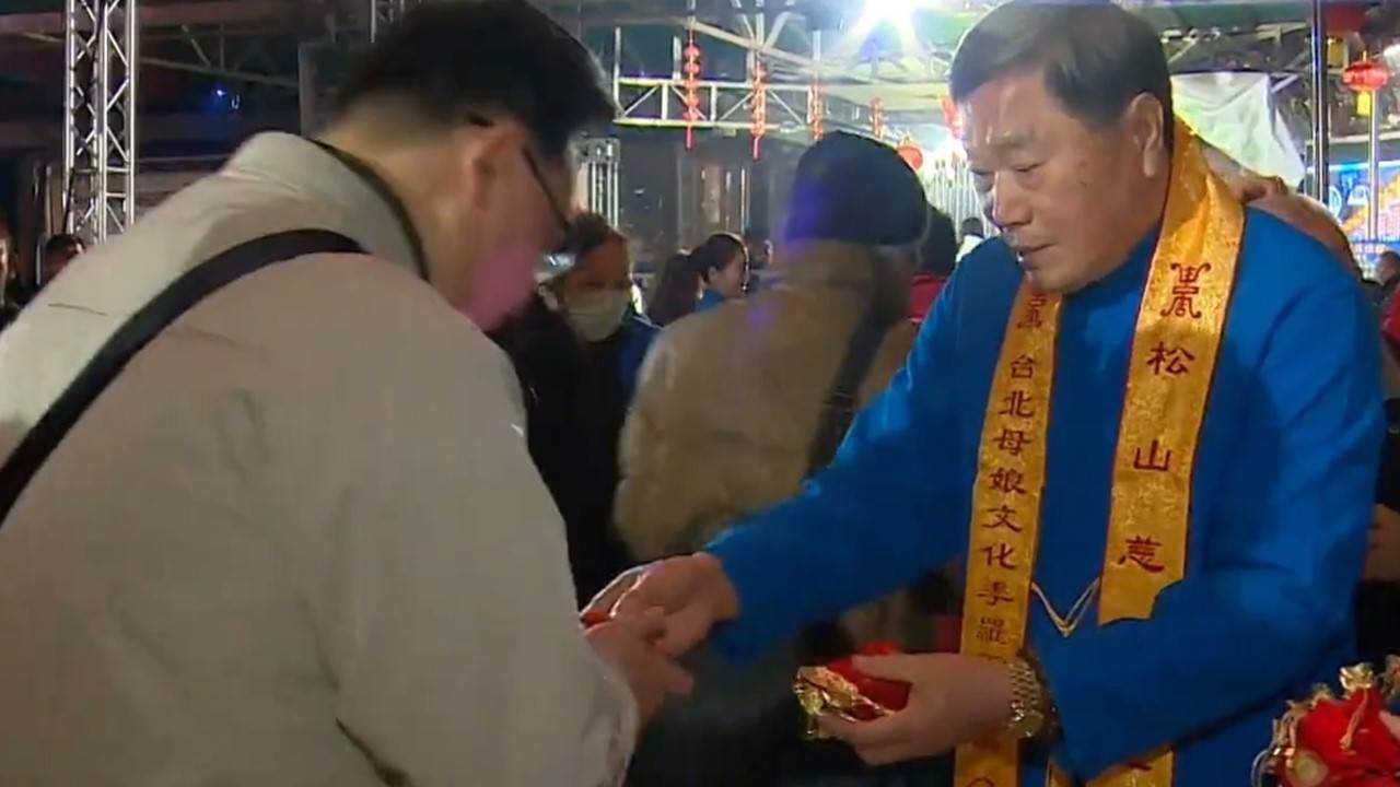 信眾不畏低溫,排隊領取松山慈惠堂錢母。