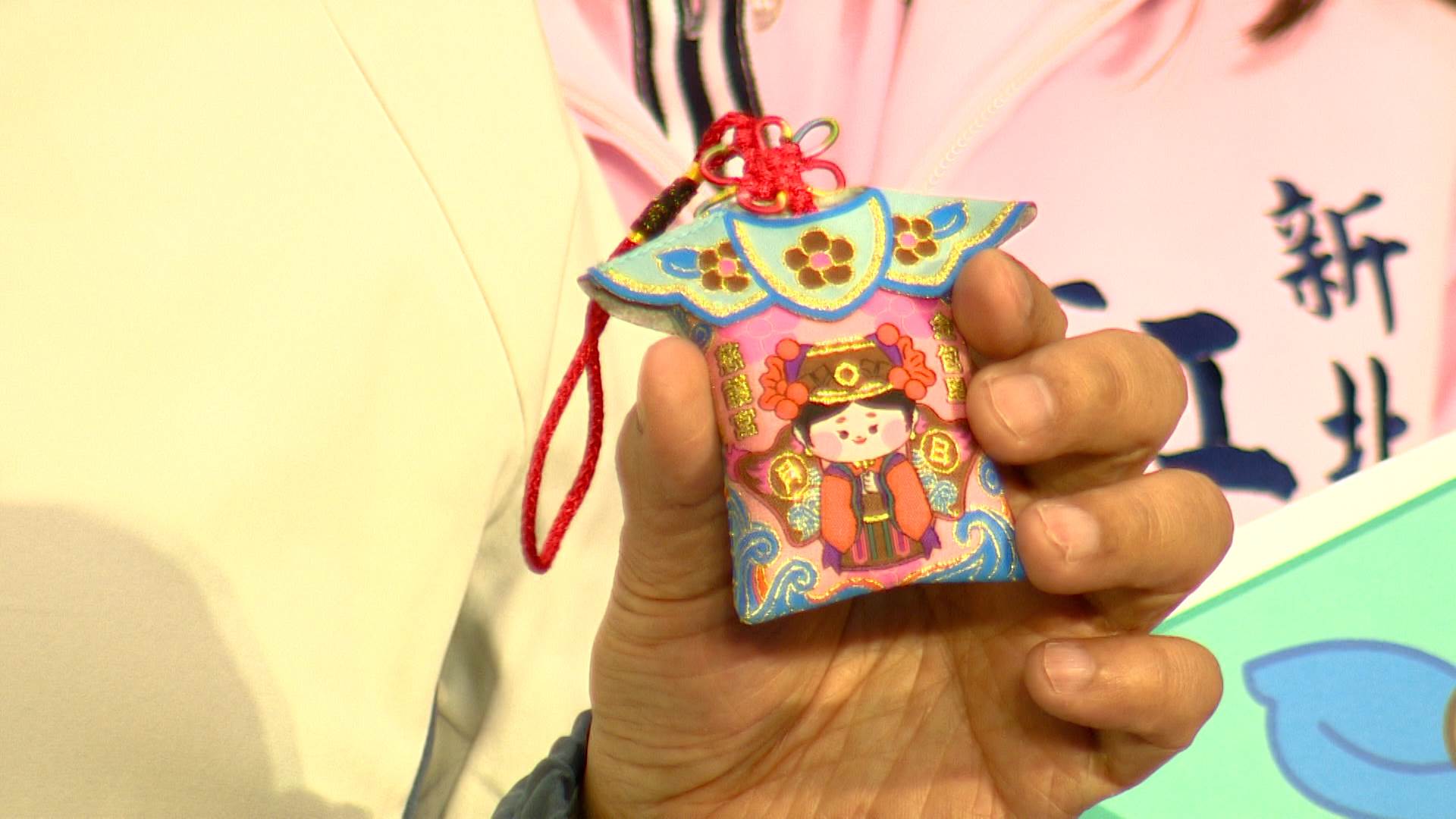 這款平安符融合了媽祖文化，設計上以神衣為造型，金線縫製的Q版媽祖形象。（圖／東森新聞）