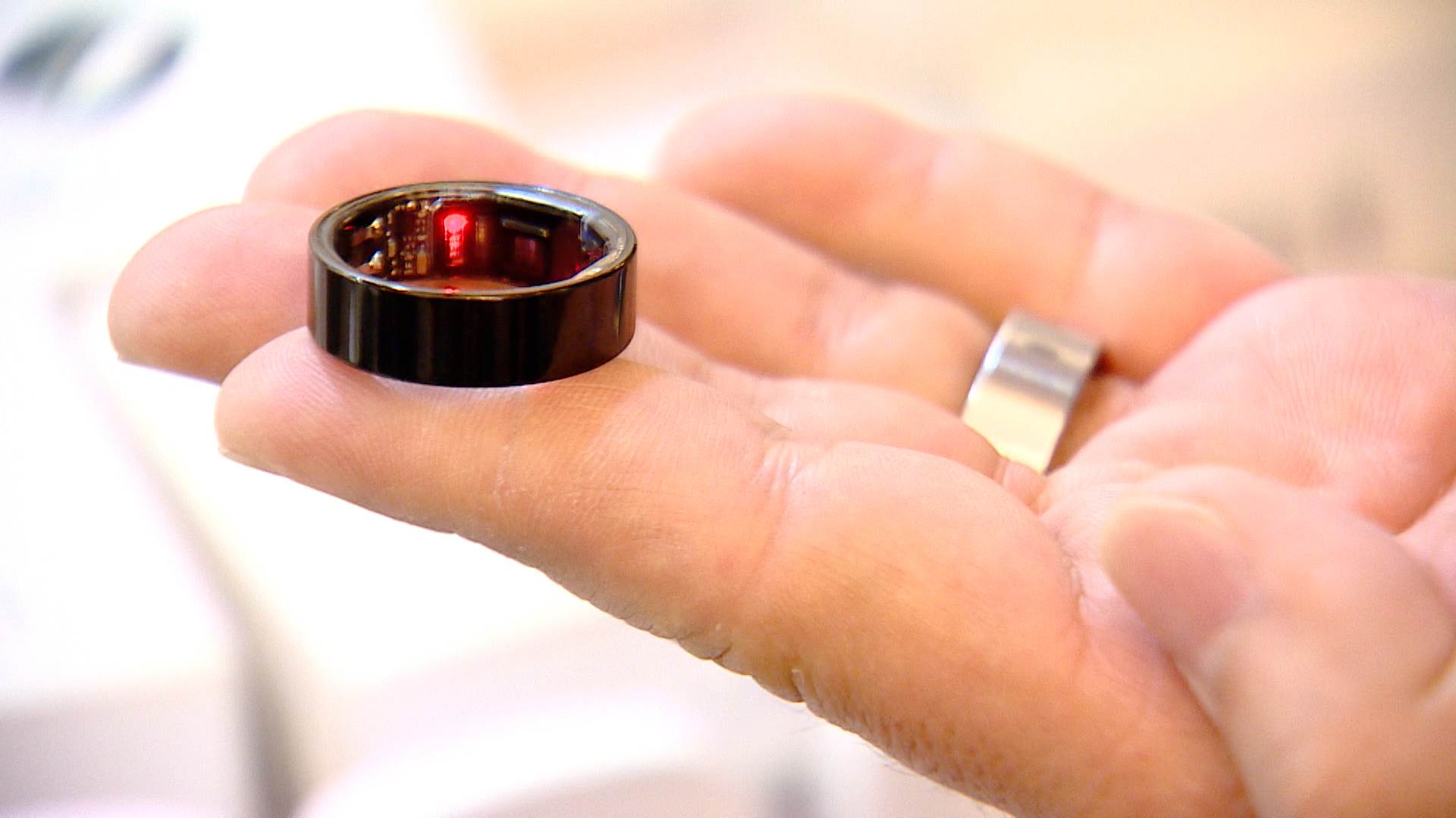 泰博科技經理陳信宏展示歐蜜瑪戒指,這款輕巧的穿戴裝置可實時監測睡眠品質、血氧、心率等健康數據,為用戶提供便捷的個人化健康管理。(圖/東森新聞)