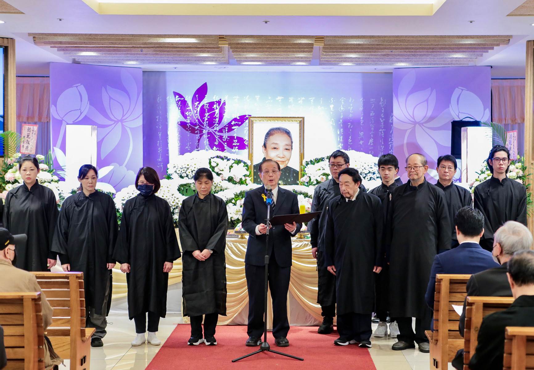 前國策顧問暨教育部吳清基部長(中)，擔任趙蘭花老夫人治喪委員會榮譽主任委員，於告別式中誦讀追思行狀。（圖／趙老夫人家屬提供）