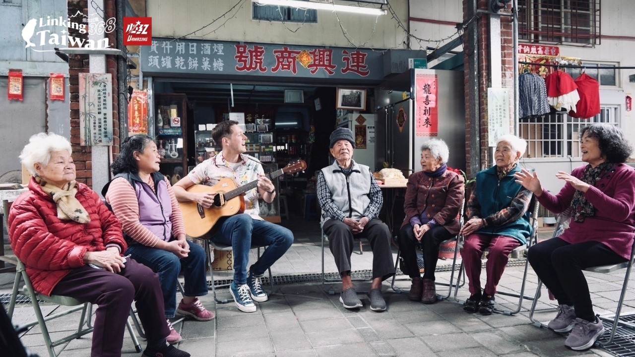 《Linking 368 Taiwan恁去台灣》主持人賈斯汀與當地的老人家坐在一起，愉快地交談分享著龍崎的故事。一邊彈著吉他，演唱著台語歌曲，場面溫馨可愛又充滿人情味。（圖／Linking 368 Taiwan恁去台灣提供）