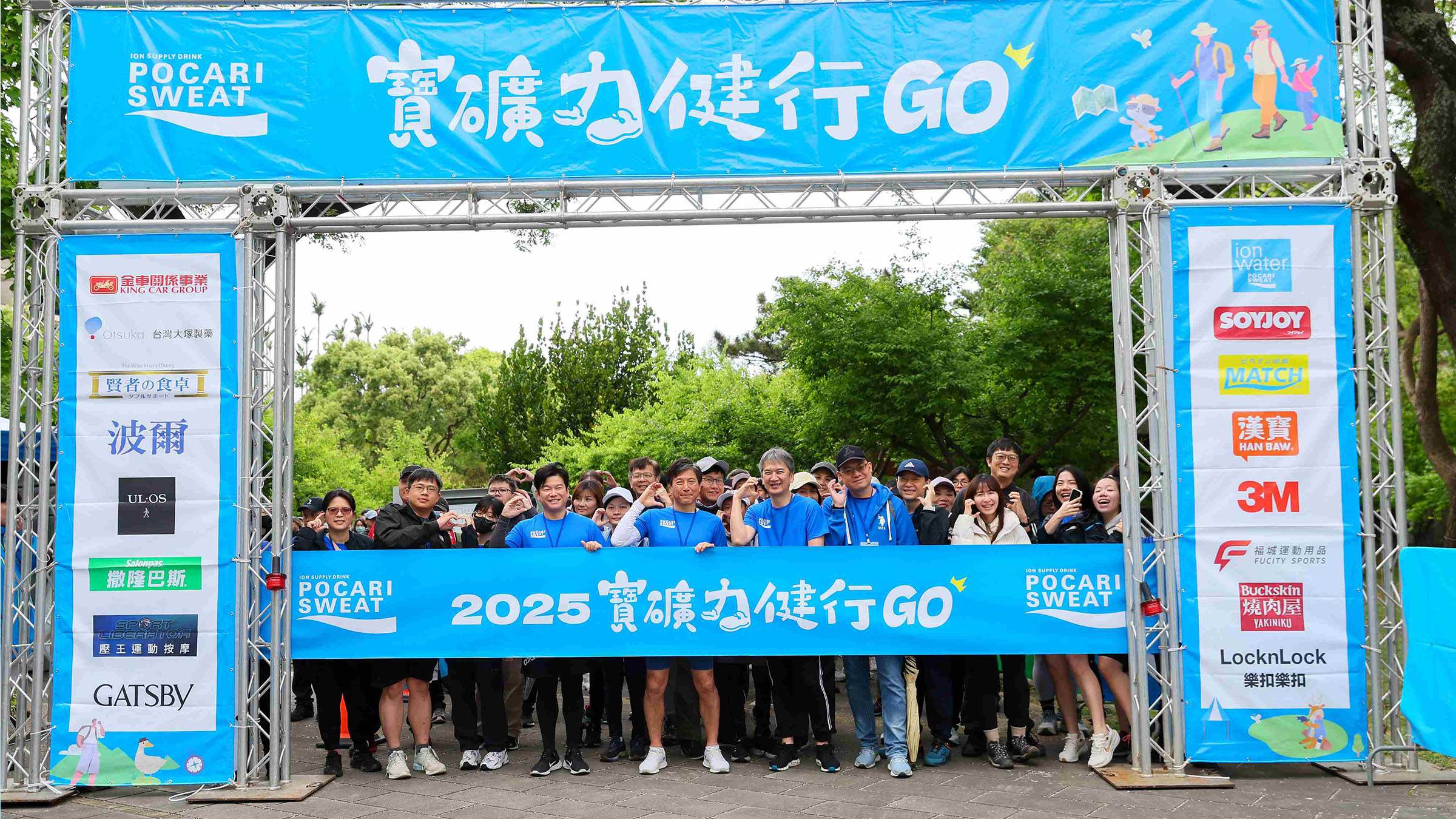 2.<a href='/search/tags/金車/' target='_blank'>金車</a>大塚船木真總經理(第1排左五)與日本大塚深瀨亮介常務(第1排左六)、台灣大塚松尾政志總經理(第1排左四)在舞台上開心向出發的民眾揮手與民眾開心地與出發拱門合影畫面