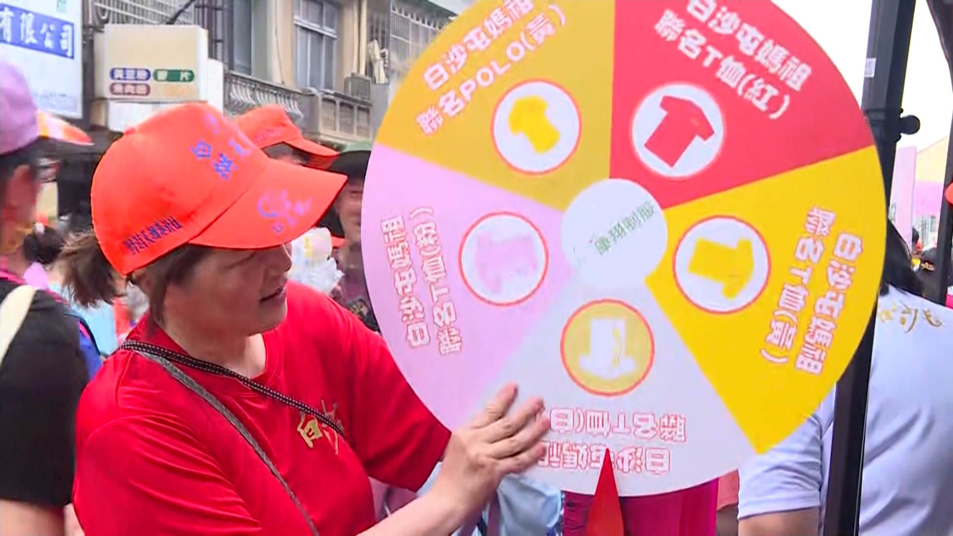 民眾依序領聯名T恤，工作人員轉轉樂，轉到哪裡就拿什麼顏色。