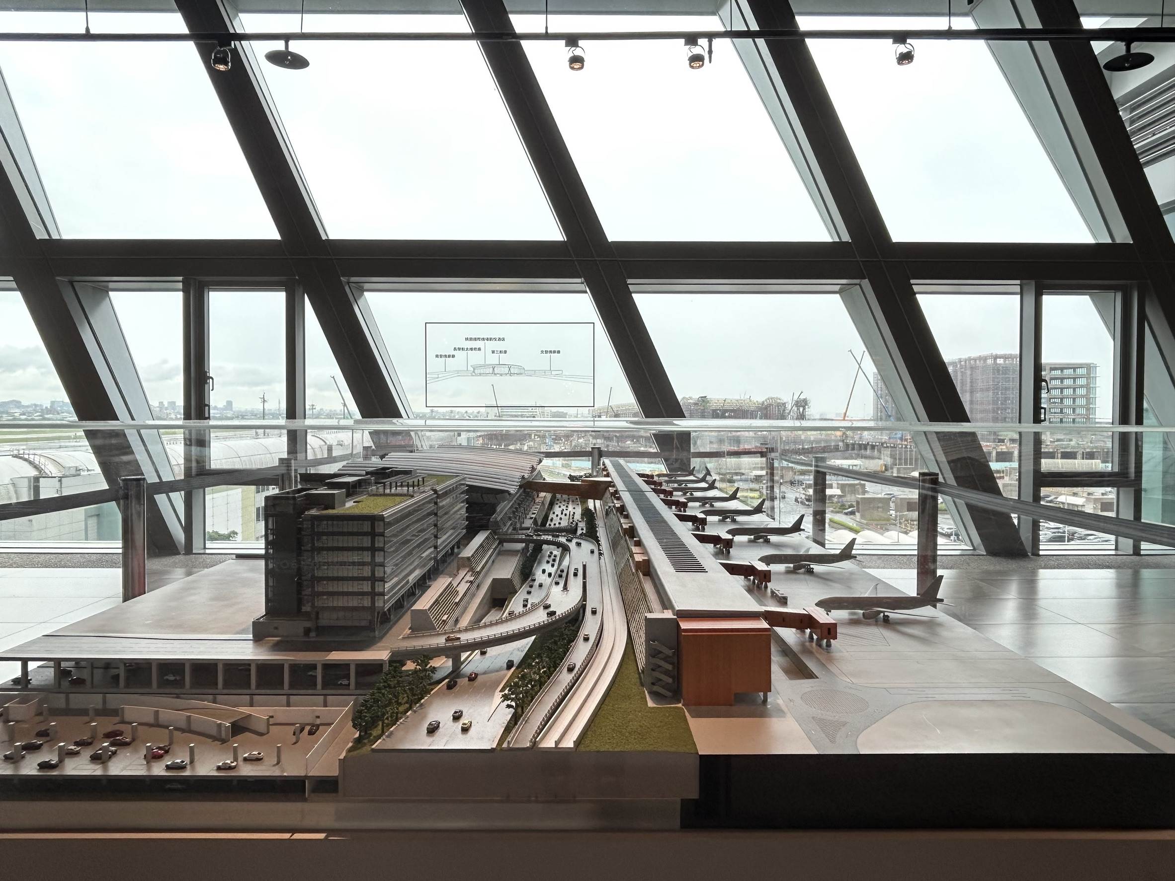 <a href='/search/tags/桃園機場/' target='_blank'>桃園機場</a>展出比例尺1：2000的第三航廈局部模型，立足模型前可透過窗貼對照窗外第三航廈施工實況，共同見證雄偉航廈的建設過程。（圖／桃園機場提供）
