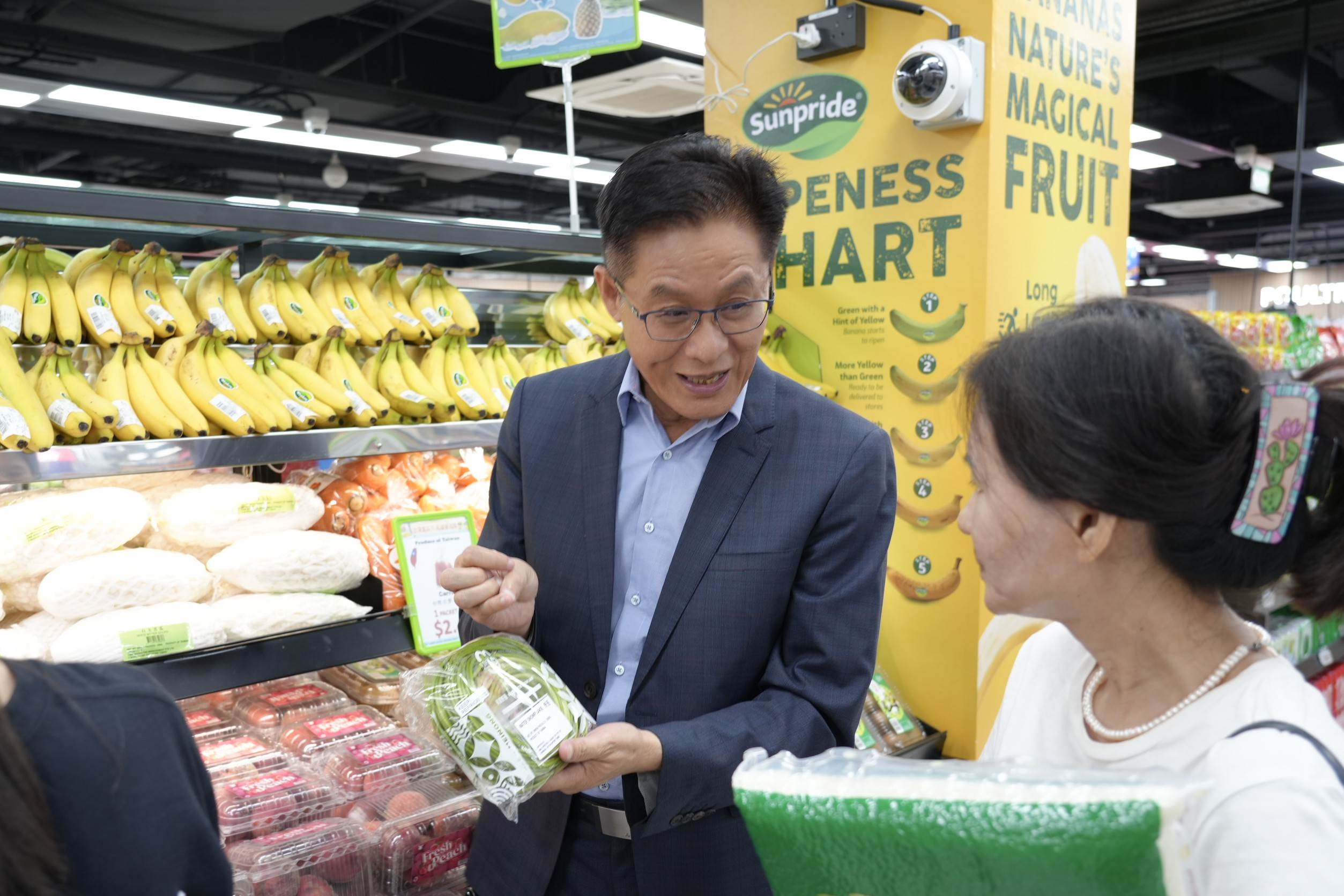 鍾清輝總幹事化身高雄蔬果推銷員介紹美濃特產野蓮。（圖／高雄市政府農業局提供）
