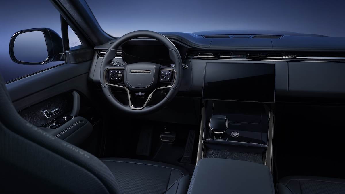 車內使用檀木黑和月光灰兩款溫莎皮革，搭配淺雲色撞色縫線，並點綴鍛造碳纖維門板細節和黑色陶瓷控制按鈕等SV標誌性設計元素。（圖／JLR Taiwan提供）