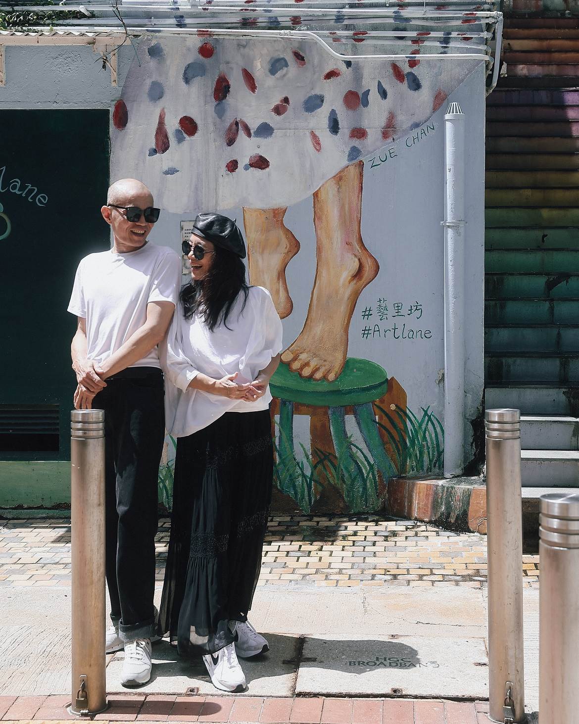 漫遊在藝里坊壁畫的繽紛色彩間，兩人的笑容比街角壁畫更鮮明動人。（攝影／余惟）