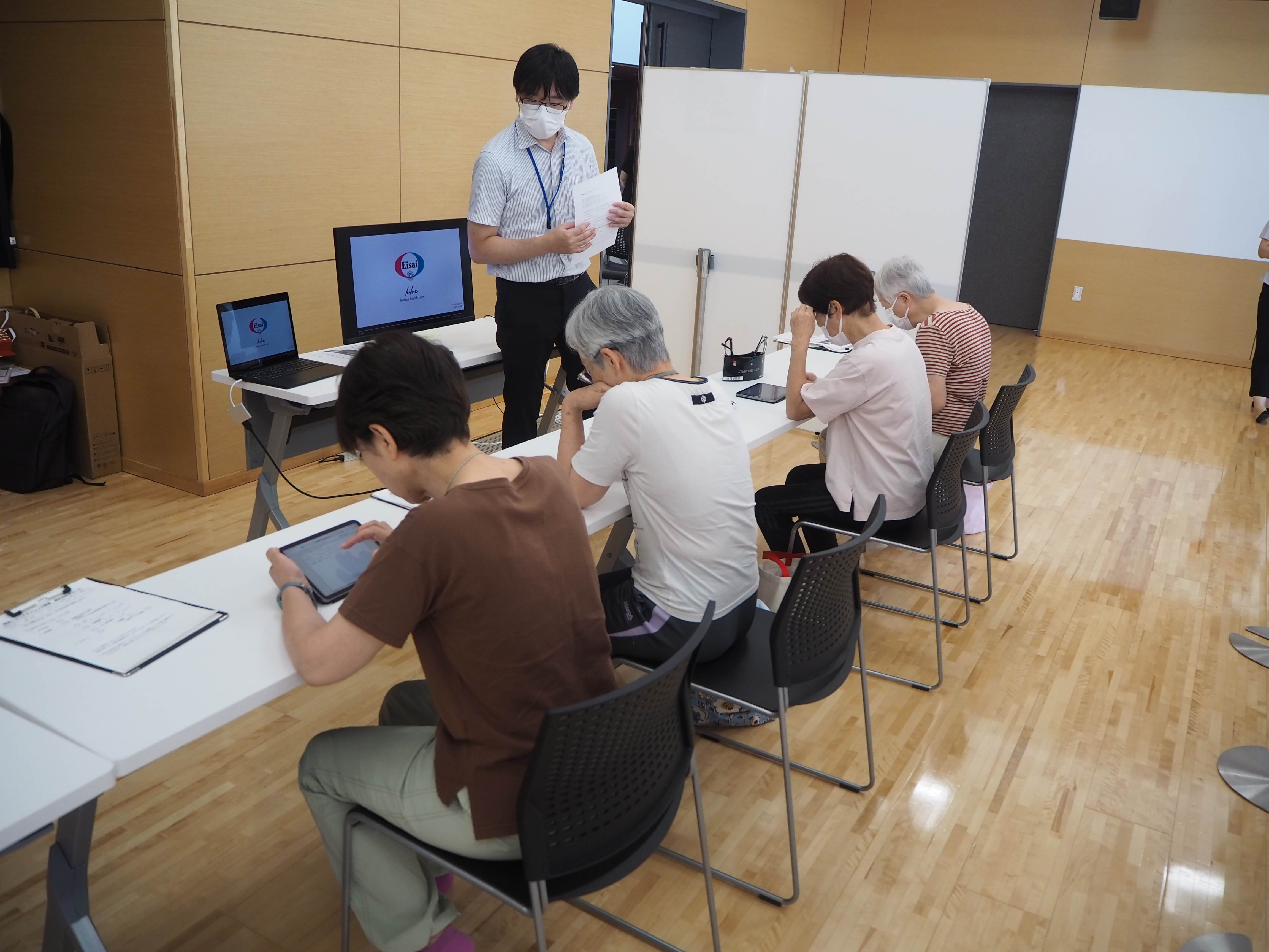 菊陽町健康長壽計畫參與者以數位平板進行認知檢測。圖／關渡醫院提供