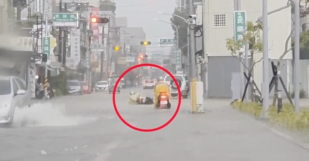 機車騎士騎車經過積水區，重心不穩打滑，跌倒受傷。（圖／東森新聞）