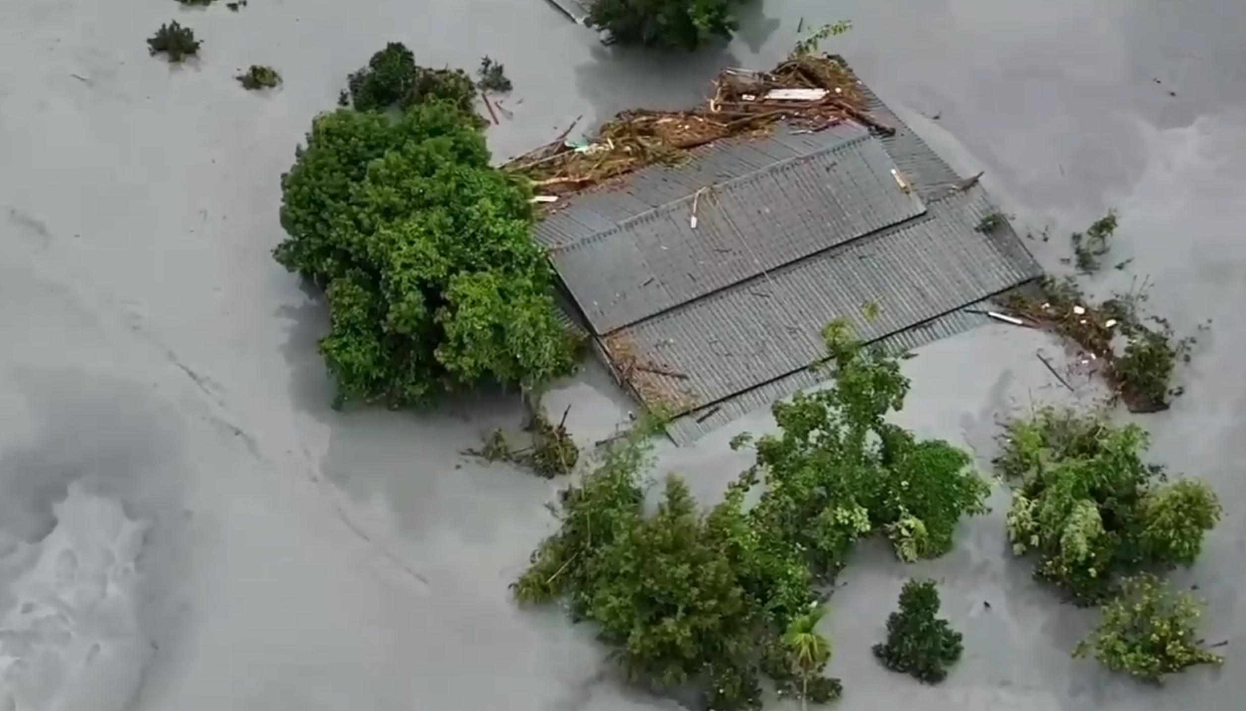 小沂受困的鐵皮平房，泥水已淹到屋簷高。翻攝畫面