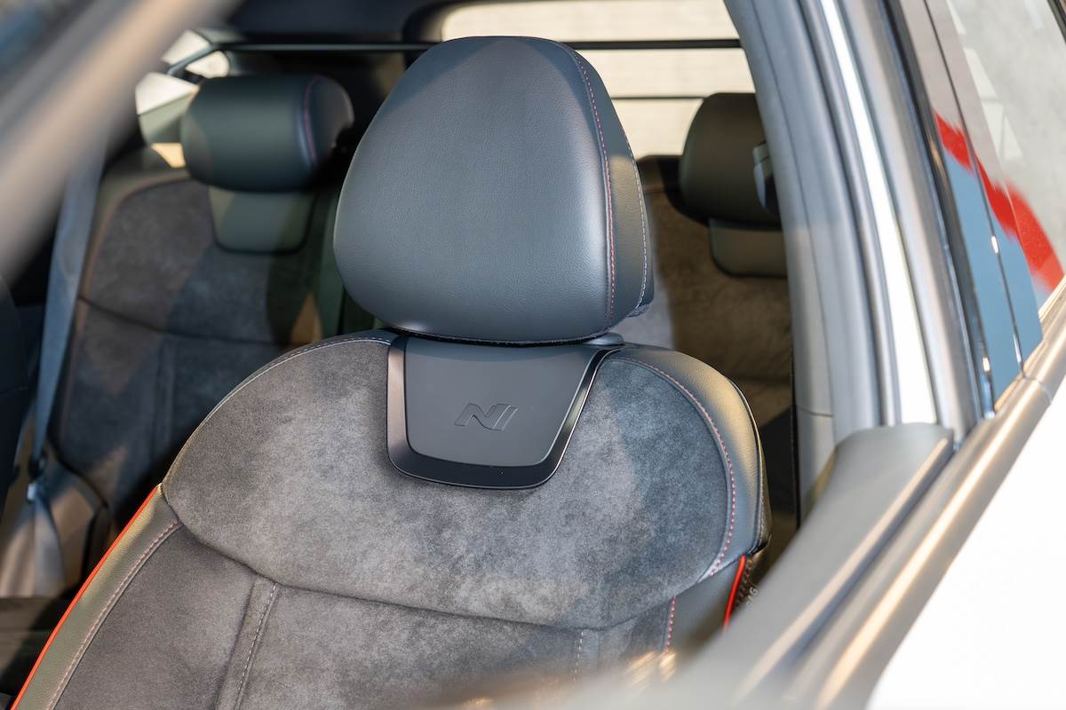 類麂皮運動座椅以紅色縫線細節勾勒，帶來紮實的包覆性與獨特觸感。（圖／林昱丞攝影）