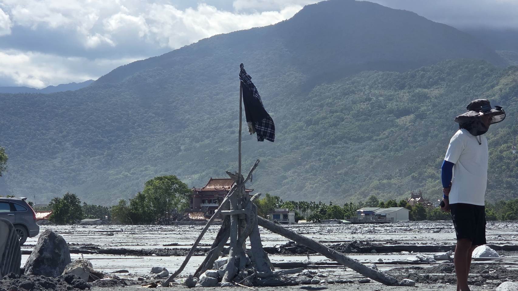 林先生在現場掛起爸媽的衣服，盼望搜救能傳來好消息。黃逸民攝