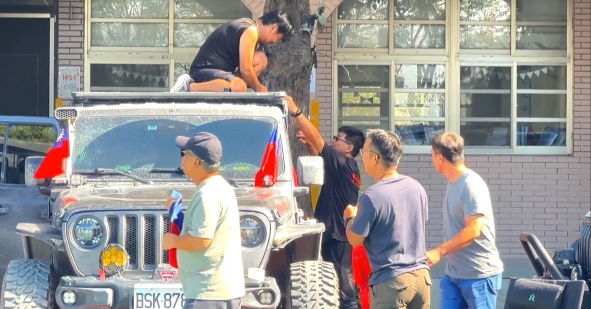 一大早志工們合力在車上貼上各種國旗，要跟光復災民們一起共同慶祝雙十國慶。（圖／東森新聞）