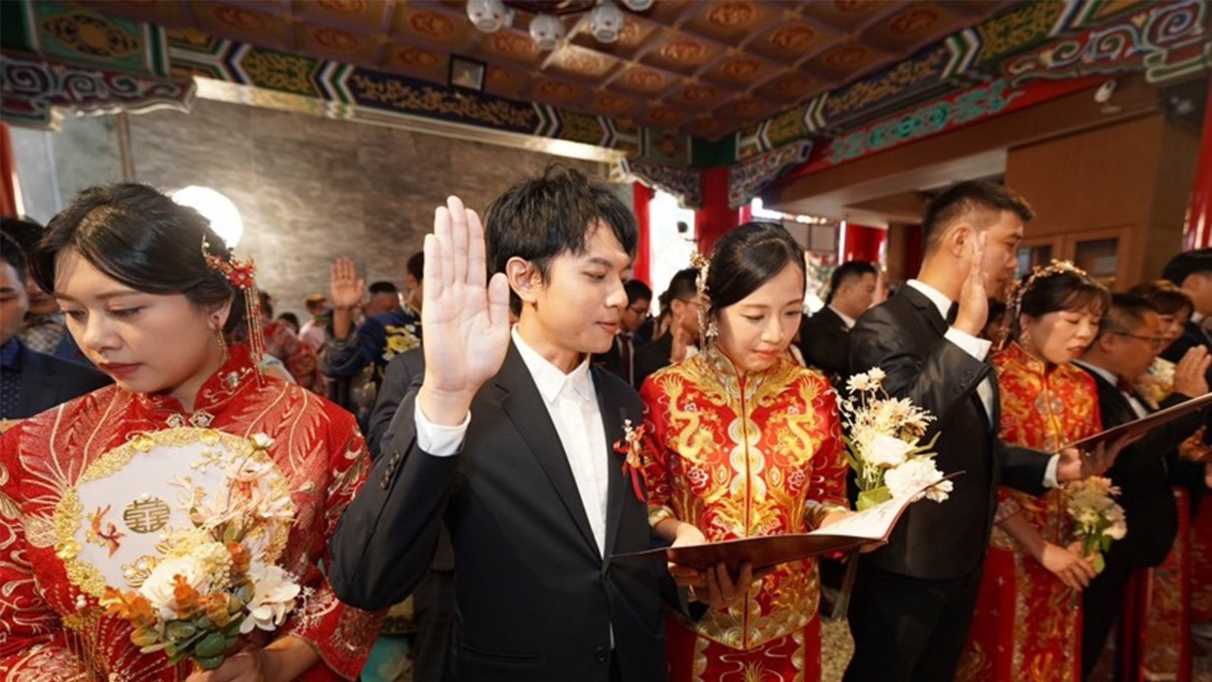 由南投縣政府主辦的「第48屆集團結婚—日月潭婚禮」今（17）日於日月潭文武廟盛大舉行，30對新人首次身著龍鳳掛齊現文武廟，在湖光山色與月老見證下，許下終身承諾，攜手完成浪漫又隆重的證婚儀式。（圖／南投縣政府提供）