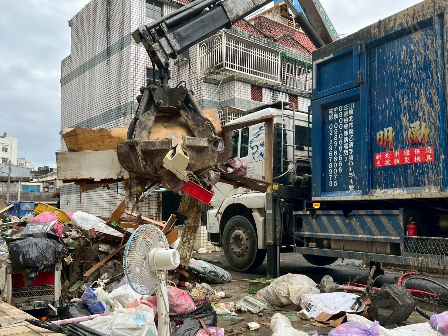 運用抓斗車清除南澳民眾排出淹水廢棄家具及廢棄物