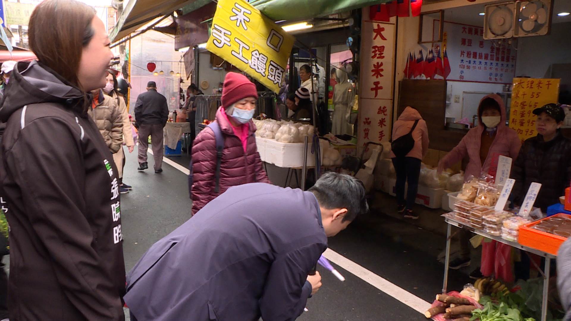 何志偉在市場掃街時，頻頻彎腰與民眾握手致意。（圖／東森新聞）