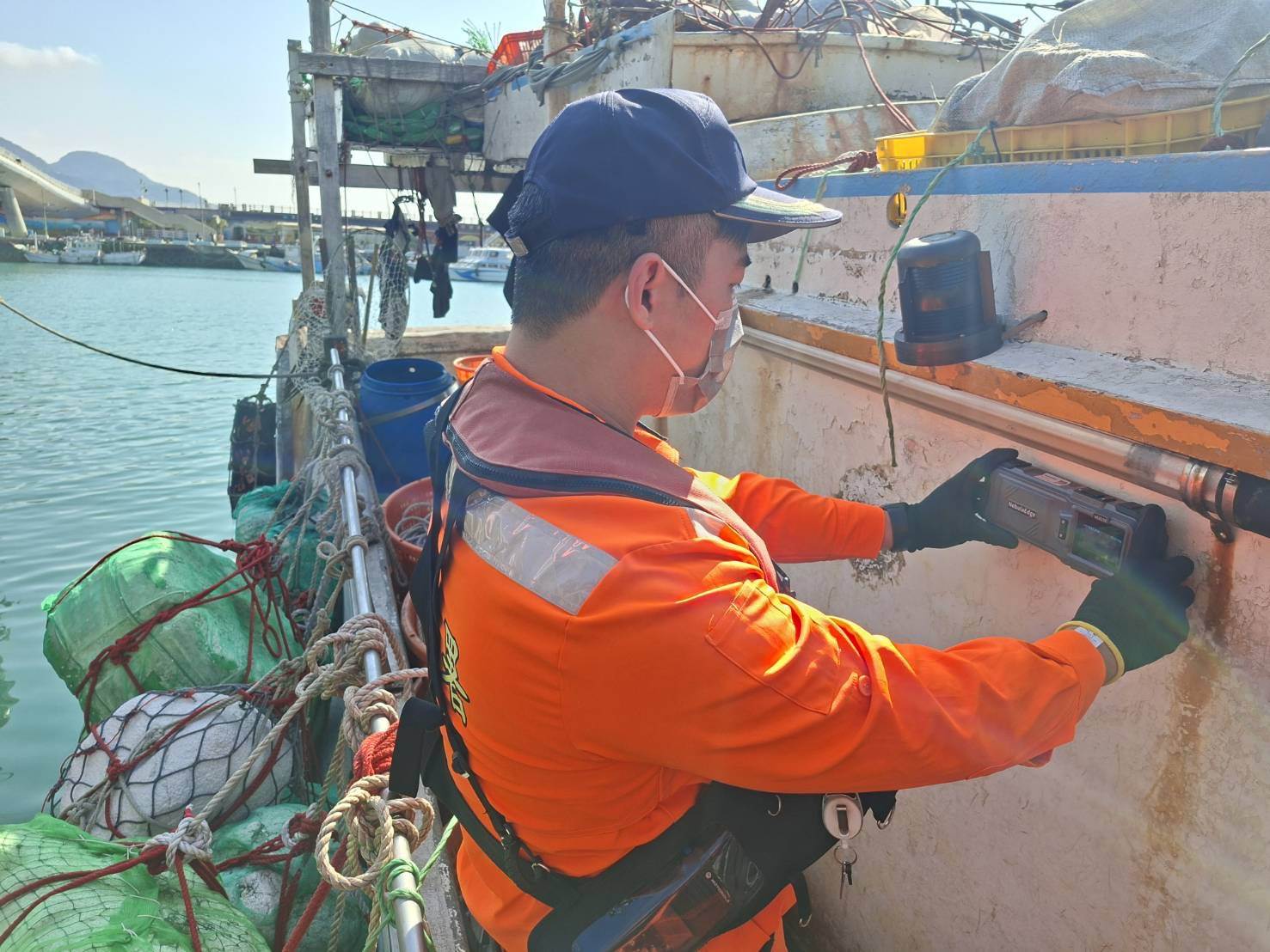 海巡人員使用手持式穿牆雷達生命探測器檢查漁船。翻攝畫面