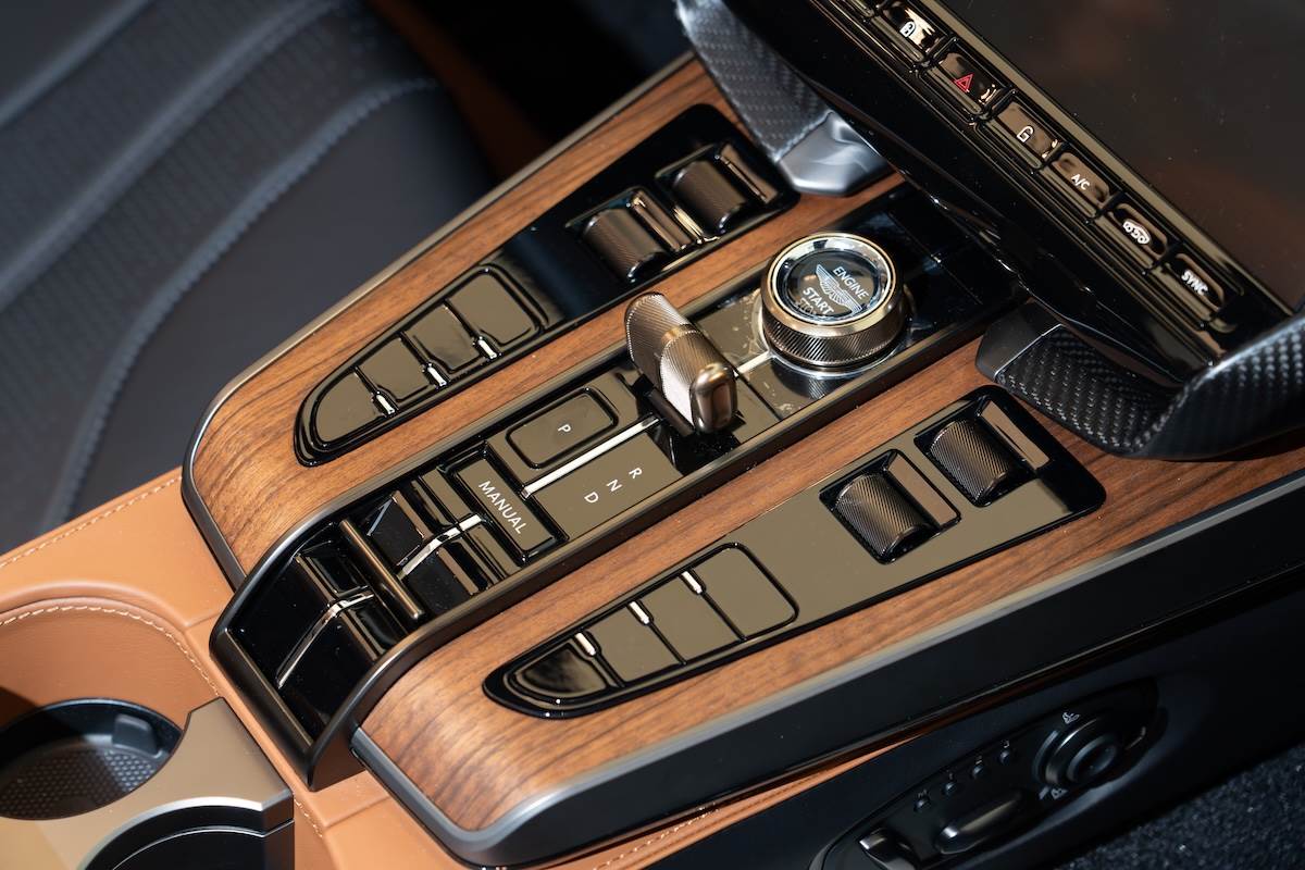 深色胡桃木飾板與古銅金金屬控制旋鈕。（圖／林昱丞攝影）