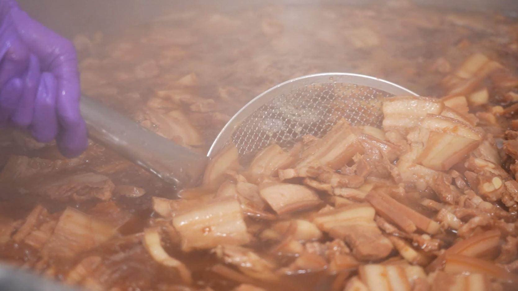 ▲把五花肉放入調好的醬汁進行滷煮。