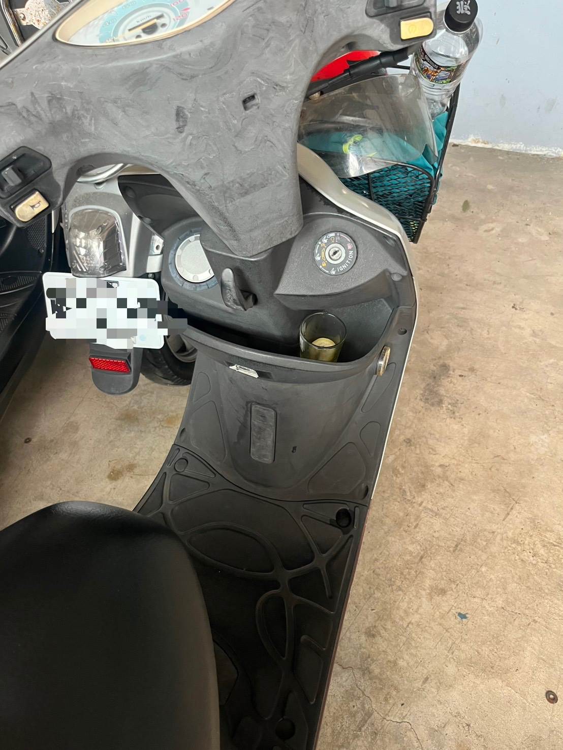 女子喝的酒杯還放在機車前方置物箱內