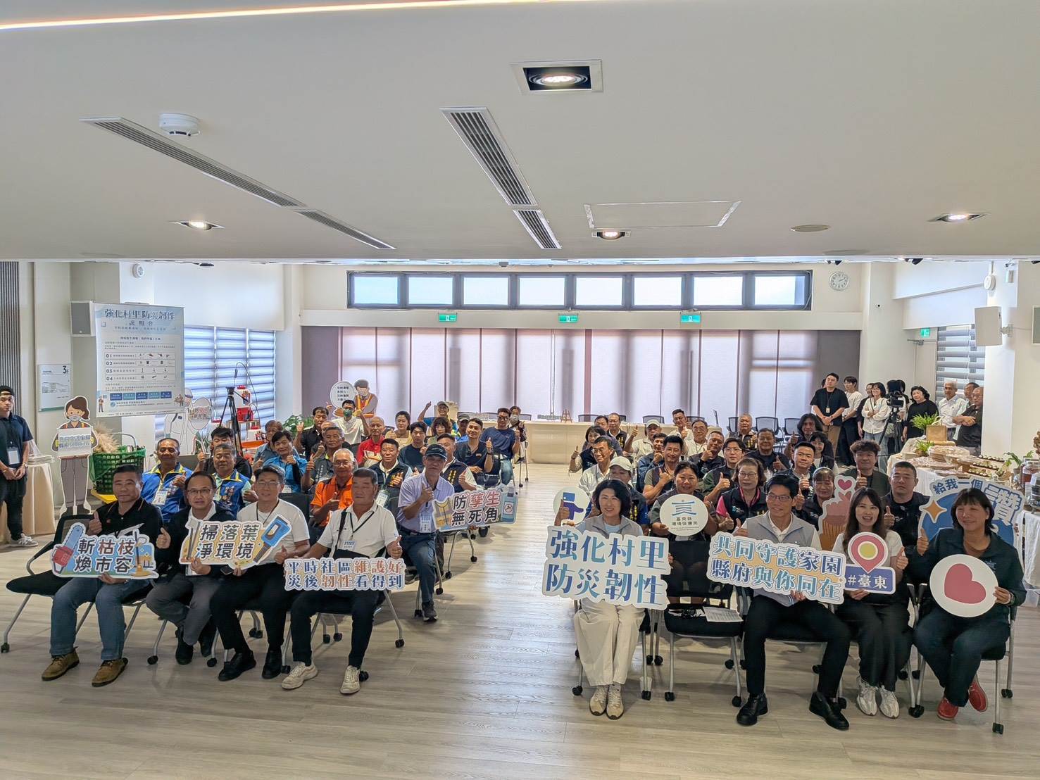 參與首場說明會的村里長與清潔隊員齊聚一堂，手持宣導牌合影，展現共同守護家園、強化村里防災韌性的決心與團結氣氛。（圖／臺東環保局提供）
