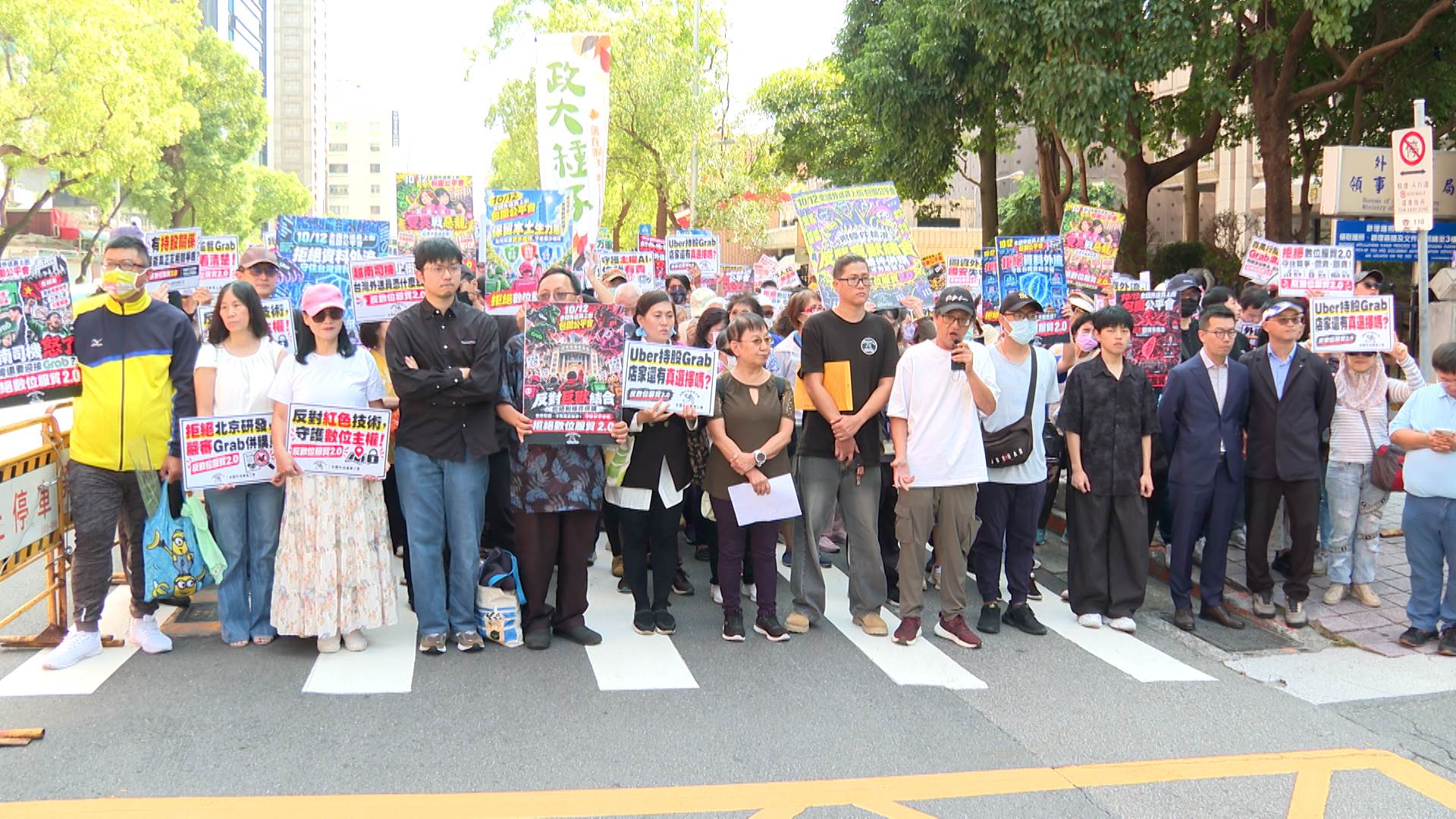 全國外送產業工會抗議團體舉起「反對數位服貿2.0」等標語，要求公平會依法駁回併購案。（圖／東森新聞）