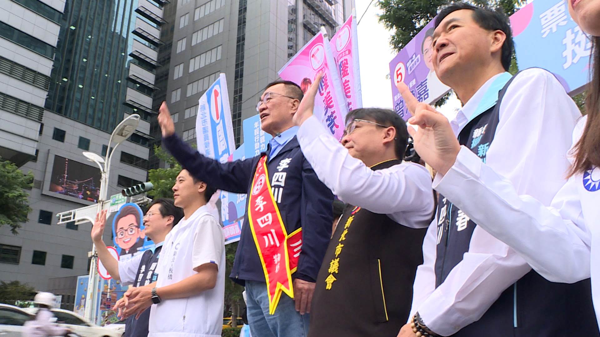 李四川率領團隊站在板橋路口懇託,向來往車輛與通勤民眾揮手拜票。(圖/東森新聞)